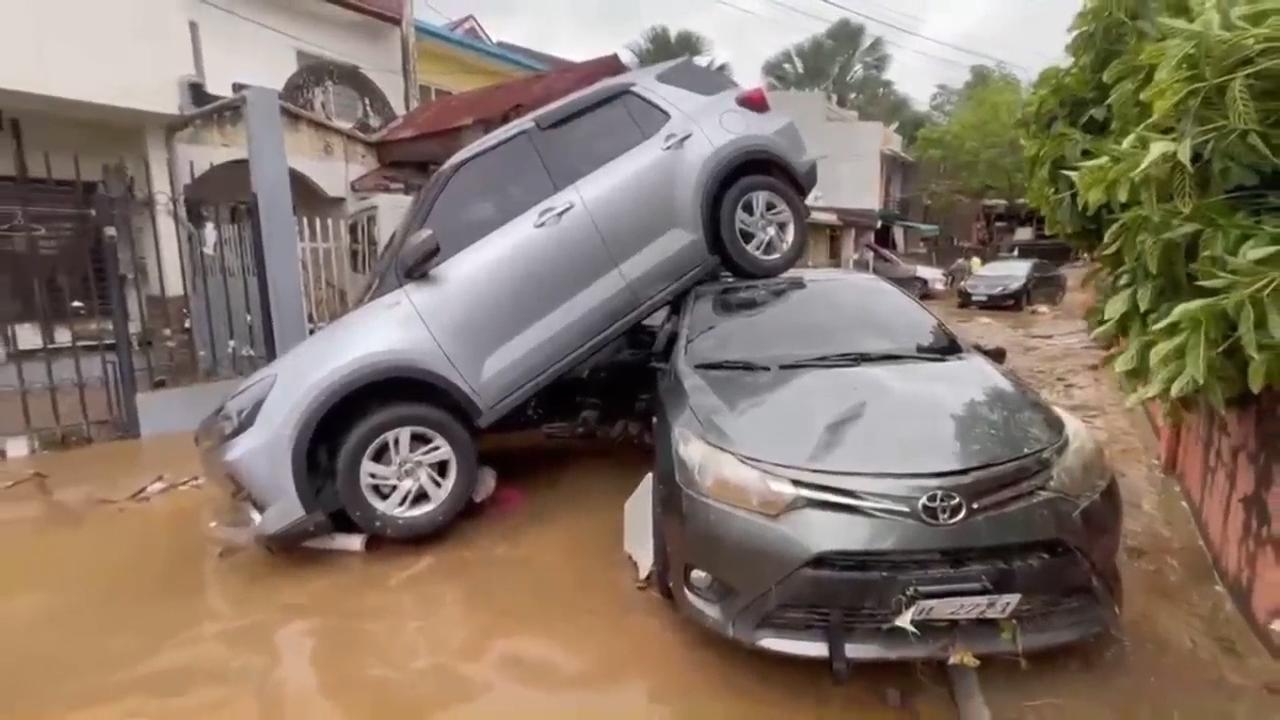 Typhoon leaves at least 2 dead, traps people on roofs and submerges cars in central Philippines