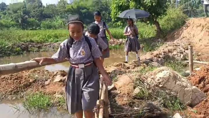 Children cross hazardous bamboo bridge daily to reach school at Rongmala Village, Charilam