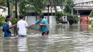 Typhoon leaves at least 2 dead, traps people on roofs and submerges cars in central Philippines