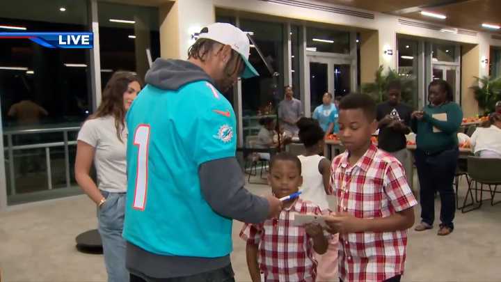 Dolphins players sign autographs, hand out food for fans in early Thanksgiving community outreach