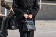 La reina Letizia con botas de tacón ancho y abrigo negro básico