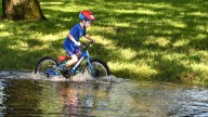 Water-filled road doesn't stop young bike rider in Photo of the Week