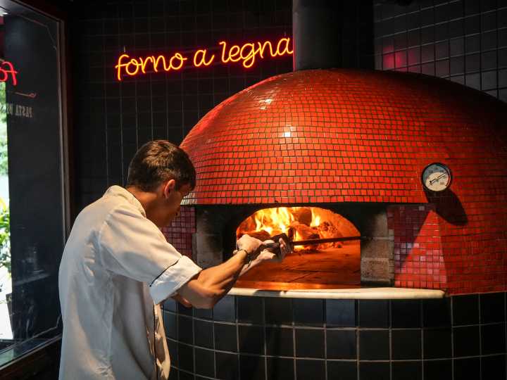 La pizza "della mamma" que se modernizó y sale de un horno que nunca se apaga