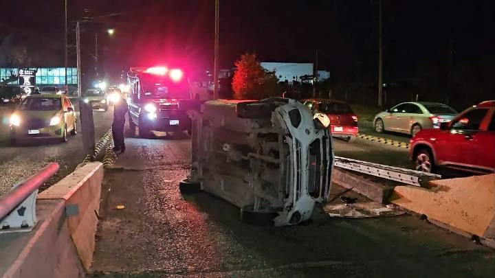 Carro volcó al chocar con base de puente