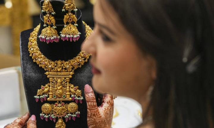 Gold gains from 1-week low as dollar declines amid peak wedding season demand