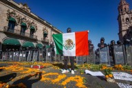 Estudiantes colocan flores y carteles frente a granaderos que resguardan el centro de Morelia