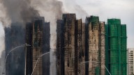 At least 65 dead as Hong Kong firefighters battle burning towers for a second day