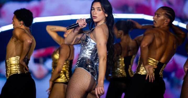 Dua Lipa Pairs Bodysuit & Fishnet Stockings in Cheeky Photo