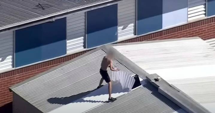 Wild prison riot sees inmates storm roof and chuck fire extinguishers at cops