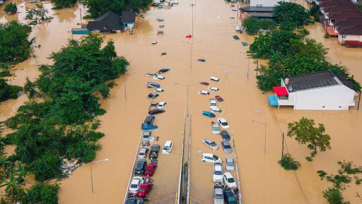 Families in southern Thailand perch on rooftops to escape flooding that has killed at least 33