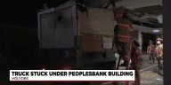 Truck stuck under People's Bank building