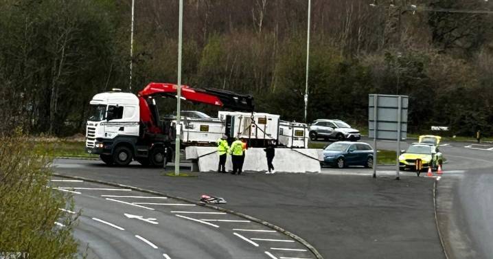 Heavy goods spilled off lorry onto busy roundabout