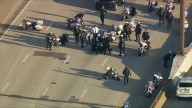 Police officer falls from motorcycle in procession on I