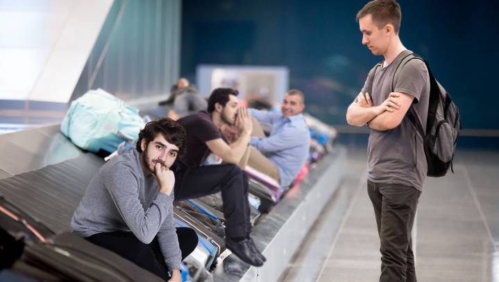 Traveler Having Trouble Finding Luggage Among Scores Of Illegal Immigrants On Baggage Claim Carousel