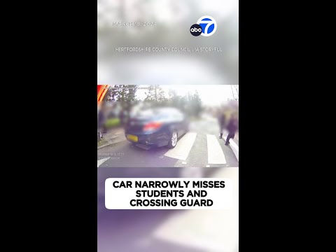 Car narrowly misses schoolkids and crossing guard