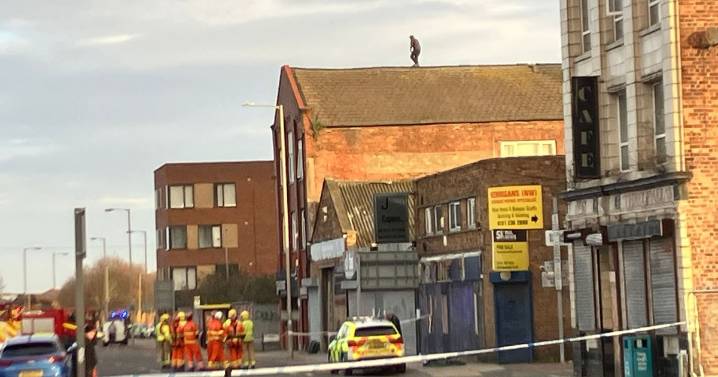 City centre street closed for hours as man on roof