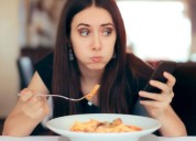 Hábito de la época. Un especialista explica por qué es malo para la salud hacer zapping o scrollear mientras comés