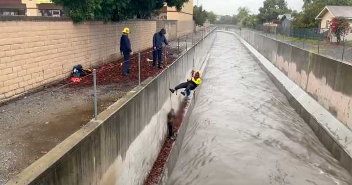 Video shows Orange County firefighters rescuing man trapped above rushing water during rainstorm