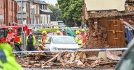 Bin lorry crashes into house on roundabout as photos show chaotic aftermath