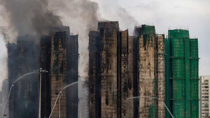 At least 65 dead as Hong Kong firefighters battle burning towers for a second day