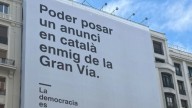 El Gobierno cuelga una gran pancarta en catalán en la Gran Vía de Madrid con motivo de los 50 años de democracia en España