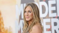 Jennifer Aniston poses in plunging black swimsuit showcasing her tanned physique