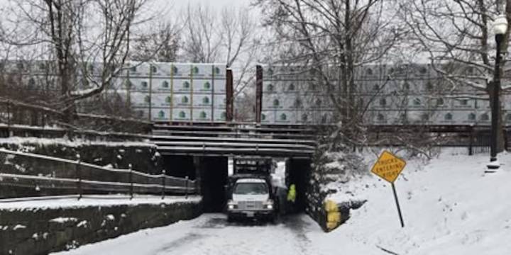 Truck stuck under railroad bridge causes road closure