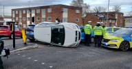Crash at busy junction leaves car on its side and road closed for almost an hour