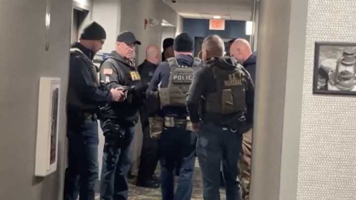 Person of interest in custody in Brown University shooting after CNN witnesses police activity at hotel