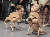 Perros robóticos con rostros de Musk y Zuckerberg en feria de arte