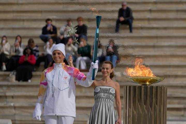 Olympic flame for Winter Games handed to Italian organizers