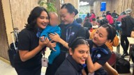 Flight attendants play with baby stranded with parent at airport