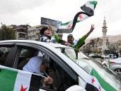 Celebrations, military parade mark one year since fall of Assad