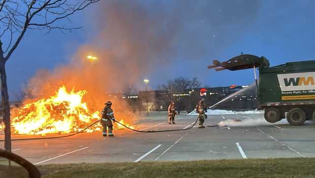Omaha sanitation worker quickly dumps garbage in parking lot after it catches on fire