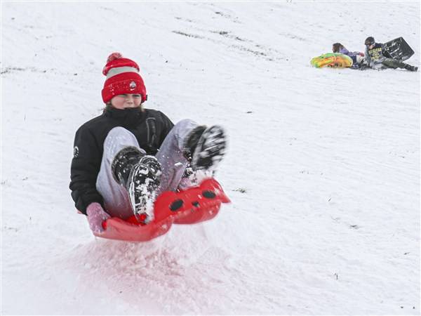 Photo Gallery: Snowfall brings out the shovels, sleds