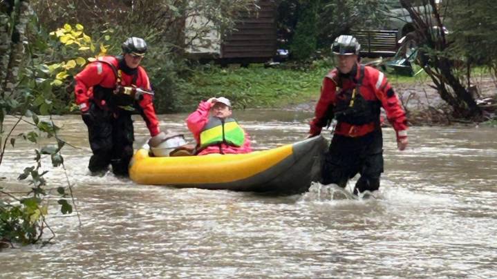 Crews brave Snoqualmie River flooding to rescue three people and dog from home