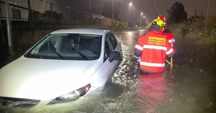 Los bomberos rescatan a dos personas atrapadas en su coche en una calle inundada en Villarreal