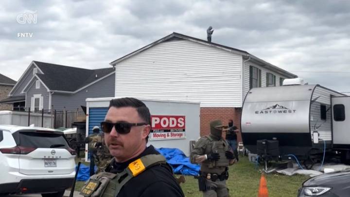 Dos hombres parecen esperar en un techo a que agentes federales se retiren