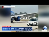 Car speeds past several planes on taxiway at Orange County airport