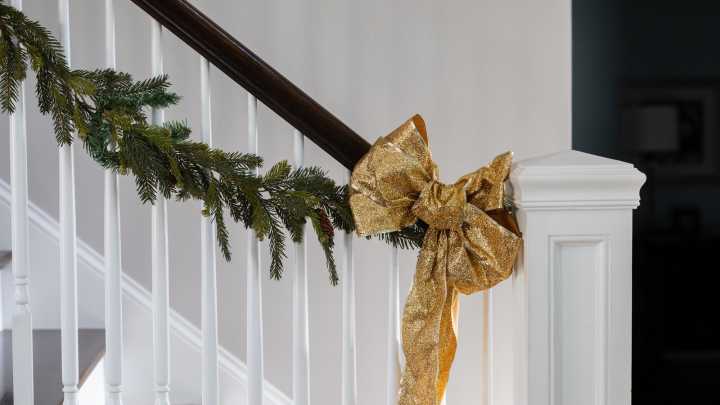 Easily Hang Your Garland From A Banister With This Simple Trick