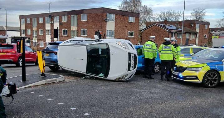 Crash at busy junction leaves car on its side and road closed for almost an hour