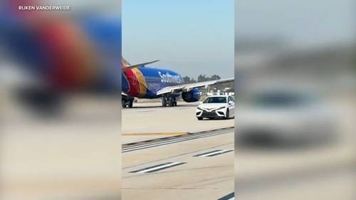 Car speeds by planes on runway at John Wayne Airport in Orange County, video shows