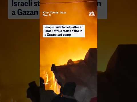People rush to help after an Israeli strike starts a fire in a Gazan tent camp