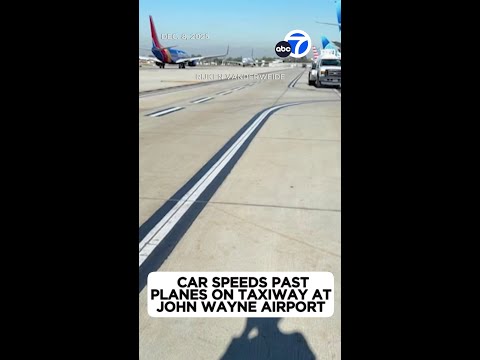Car speeds past planes on taxiway at John Wayne Airport
