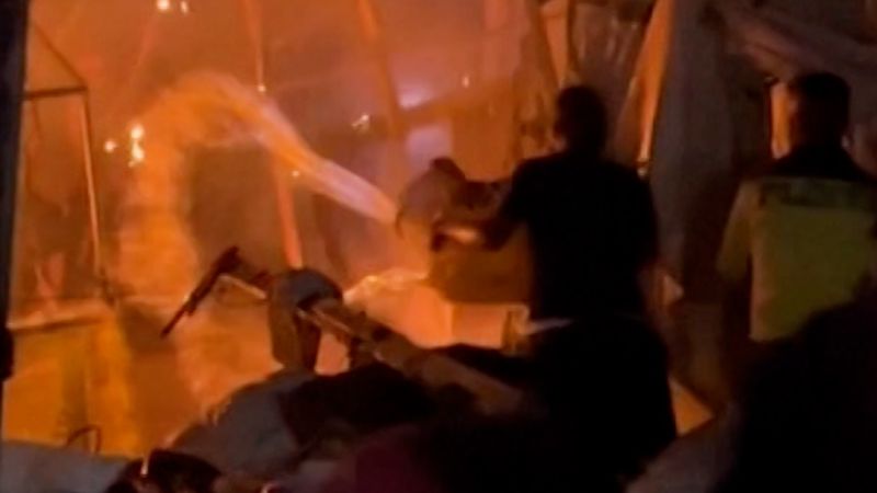 Palestinians frantically pour water on a blaze caused by an Israeli strike