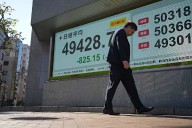 US futures slip and Asian stocks are mixed, while oil prices surge more than $1 a barrel