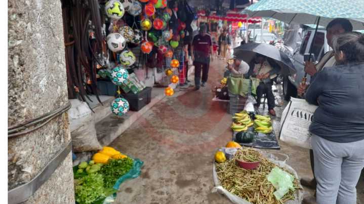 La necesidad obliga a vendedoras del agro a trabajar bajo la lluvia