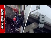 Driver rescued after crashed truck left hanging over bridge