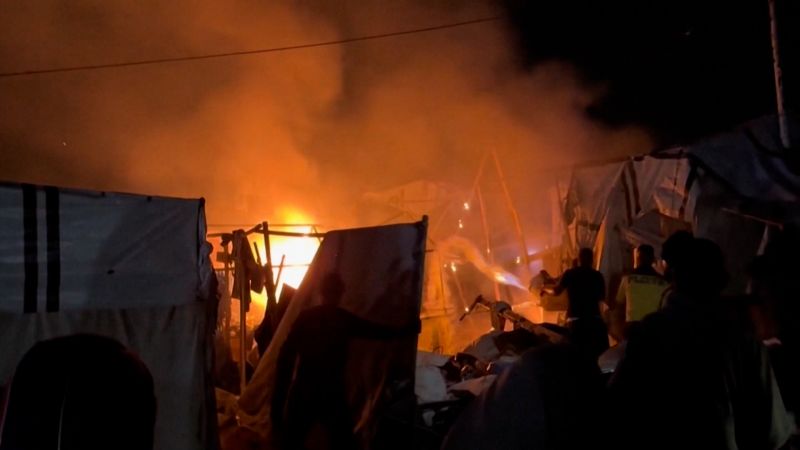 Palestinos echan agua frenéticamente sobre un incendio causado por un ataque israelí