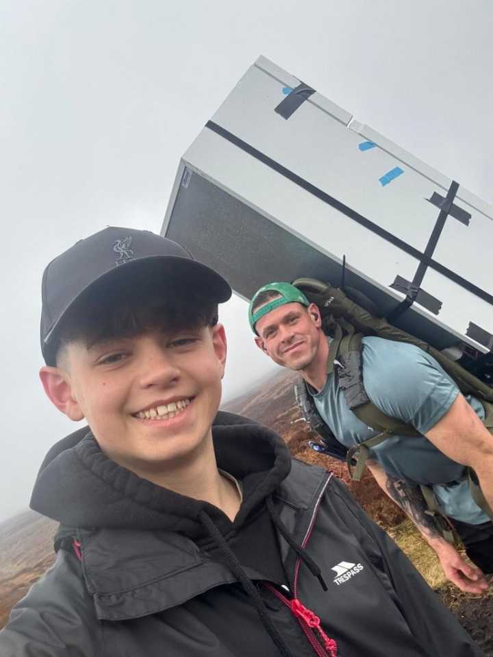 Man Carries Fridge On Back While Completing 70-Mile Hike In Honor Of Late Wife